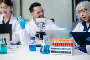 Scientists in lab coats collaborating with test tubes, flasks, and microscopes in a modern lab.