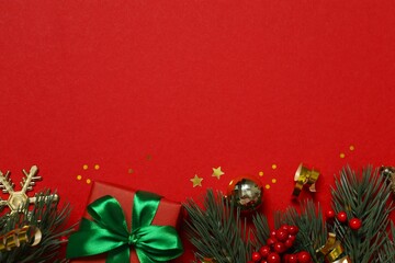 Beautiful gift box tied with bow Christmas decorations, confetti on color background 