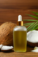 Bottle of coconut oil on wooden background