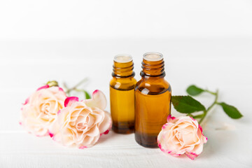 Rose essential oil on a textured background.Roses and a bottle of rose perfumed water.Aromatherapy treatment. Beauty concept. Spa procedure.Natural organic oil.Anti-stress,detox relax.Place for text