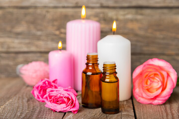 Rose essential oil on a textured background.Roses and a bottle of rose perfumed water.Aromatherapy treatment. Beauty concept. Spa procedure.Natural organic oil.Anti-stress,detox relax.Place for text