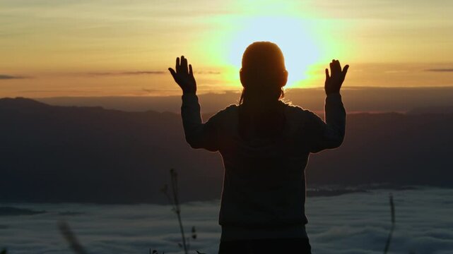  Silhouette of Person hands open palm up worship God helping repent catholic easter lent mind pray Christian religion.  prayer woman worship God in the morning with sunrise.
