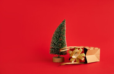 Christmas tree and gift on red background. Space for text. New Year 2025 sales