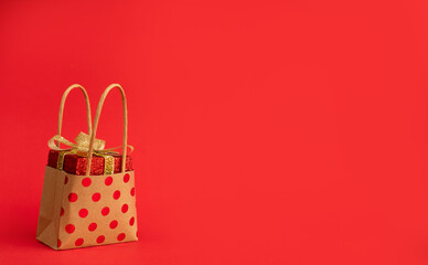 A bag with a gift on a red background. Christmas or Valentine's Day. Holiday sales