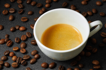 ristretto with crema in cup and coffee beans near on black table