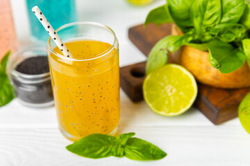 Diet detox cocktail with basil and chia seeds in a glass jar and a glass on a textured background....