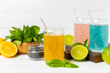 Diet detox cocktail with basil and chia seeds in a glass jar and a glass on a textured background....
