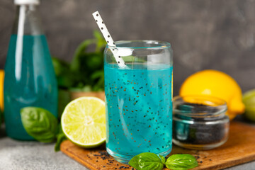 Diet detox cocktail with basil and chia seeds in a glass jar and a glass on a textured background....