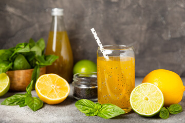Diet detox cocktail with basil and chia seeds in a glass jar and a glass on a textured background....