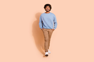 Full body photo of confident middle eastern guy wear blue shirt trousers hold arms in pockets...
