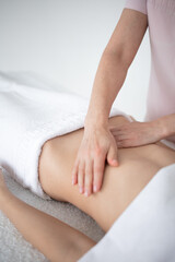 A woman receiving a belly massage at a beauty salon