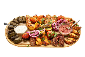 A wooden tray with a variety of meats and vegetables, including chicken wings