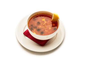 A bowl of soup with a lemon slice on top