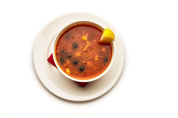 A bowl of soup with a lemon slice on top