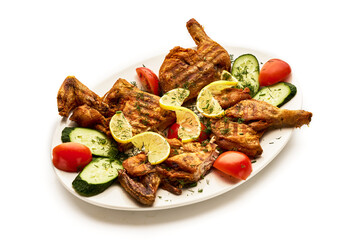 A plate of chicken and vegetables with lemon slices