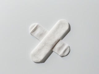 Two adhesive bandages are crossed over each other.