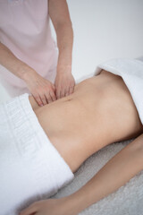 Fototapeta premium A woman receiving a belly massage at a beauty salon