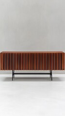 Modern wooden cabinet with vertical slats on black metal legs in a minimalist living room against a gray wall