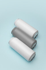 Minimalistic grey and white cans, lying against blue background. Mockup for beer, soda drinks advertisement. Ideal for branding and product placement with focus on modern aesthetics.