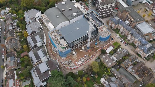 Fly-out aerial of Ealing Studios redevelopment emphasizing construction spread, Ealing, London
