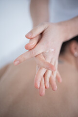 Closeup of masseuse hands. he rubs the oil in his hands