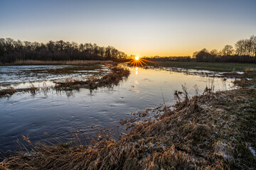 sunset over a flooded Drentsche Aa river in winter season - Oudemolensche Diep, Drenthe, The...