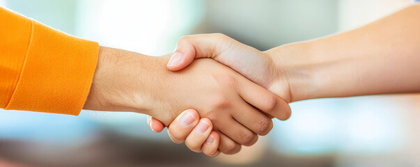 Two hands shaking, symbolizing agreement or partnership in a professional context.