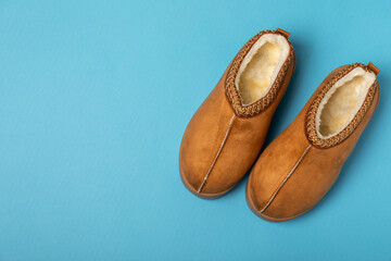 Soft slippers on a bright colored background, close-up. House slippers. Comfortable shoes for home. Foot care concept. Home comfort. Space for text. Copy space.