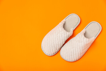 Soft slippers on a bright colored background, close-up. House slippers. Comfortable shoes for home. Foot care concept. Home comfort. Space for text. Copy space.