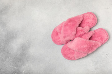Obraz premium Soft slippers on a bright colored background, close-up. House slippers. Comfortable shoes for home. Foot care concept. Home comfort. Space for text. Copy space.
