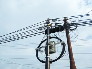 Internet cable installation poles in Indonesia. Silhouette of a pole and internet cable...