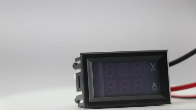Voltmeter and ammeter display module that is used in electronics applications rotating on a display table on a white background