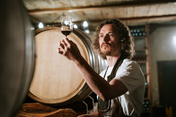 Winemaker Inspecting Red Wine in Cellar