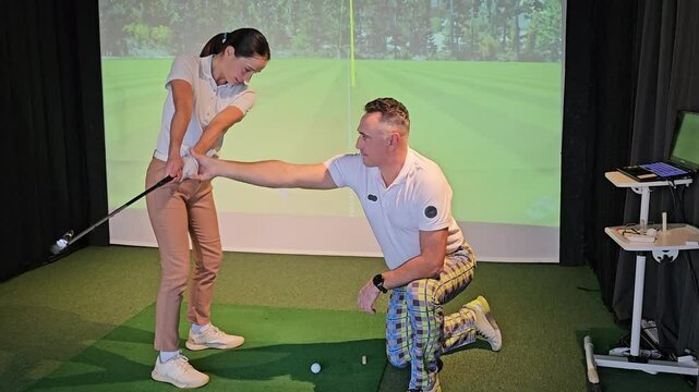Golf training session with instructor demonstrating swing techniques indoors