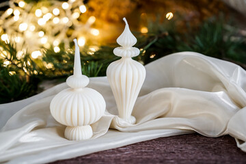 Ribbed Eco-friendly candles made from soy and olive oil wax, surrounded by pine branches and festive lights.