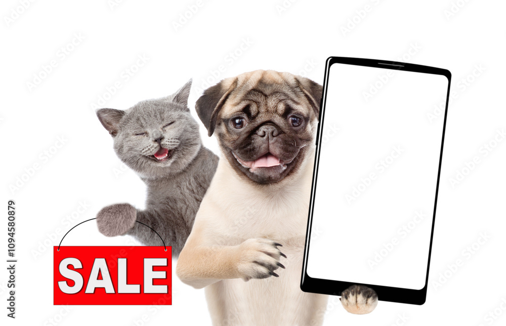 Fototapete Smiling Pug puppy holds big smartphone with white blank screen in it paw, showing close to camera. Happy cat showing signboard with labeled 