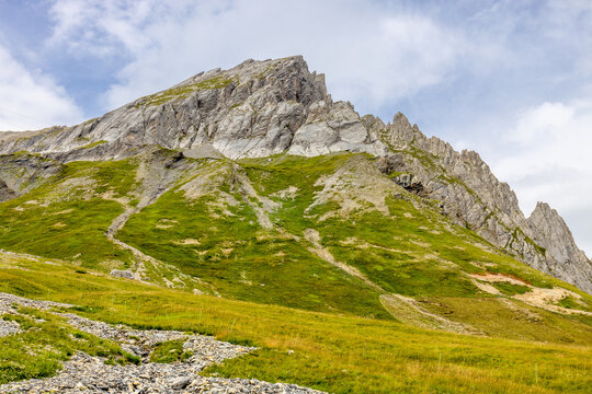 Tour du Mont Blanc beautiful landscapes in the Alps mountains on a sunny summer day. Green grass on the alpine meadow surronded by high mountain peaks of Montbalnc alpine range