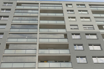 The facade of a modern apartment building features striking design with glass balconies and large windows