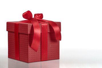 A beautiful dark red gift box with a charming red ribbon on a white