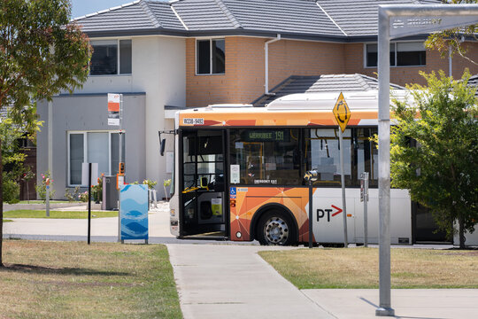 A bus parked in a suburban neighborhood with its door open, waiting for passengers in Wyndham Vale, Melbourne, Australia.