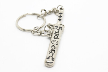 Close-Up of Ornamental Sword Keychain on White Background