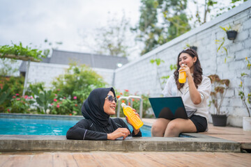 Friends relax by the pool, sipping drinks and enjoying good company under the sun