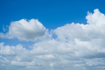 Blue sky filled with white, fluffy clouds on a sunny day