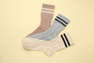 Different comfortable socks on beige background, flat lay