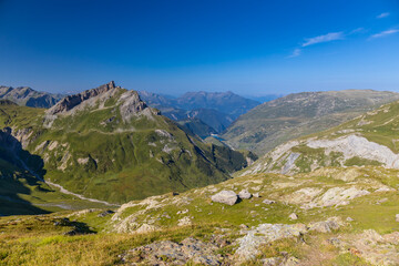 Fototapeta premium Tour du Mont Blanc beautiful landscapes in the Alps mountains on a sunny summer day. Green grass on the alpine meadow surronded by high mountain peaks of Montbalnc alpine range
