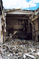 Reinforced concrete roof structures and metal sheets of an industrial building collapsed after a fire. Building debris.