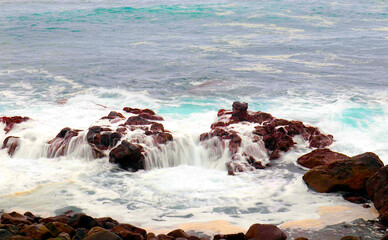 Waves crashing against volcanic rocks in Saint Helena: Nature’s power and beauty on display as the sea meets the rugged, untouched coastline..