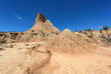 Eroded rock and mud formations in the Los Monegros desert, Huesca under an intense blue sky