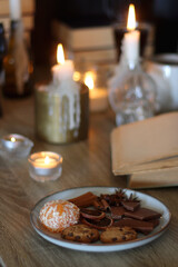 Books, lit candles, red wine, snacks and various deocration on the table. Dark academia or Halloween concept. Selective focus.