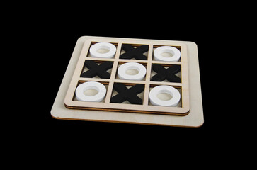 A wooden game set of noughts and crosses on a black background